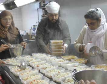 Volunteers packing food containers in a kitchen